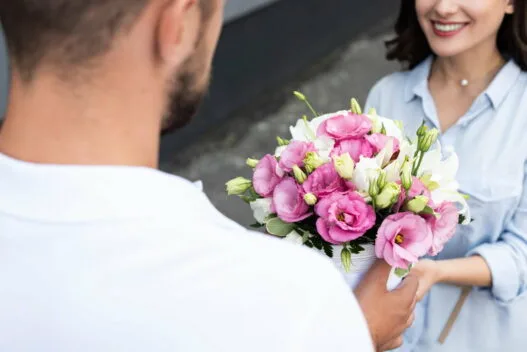 Kvinde der modtager en buket blomster fra et blomsterbud